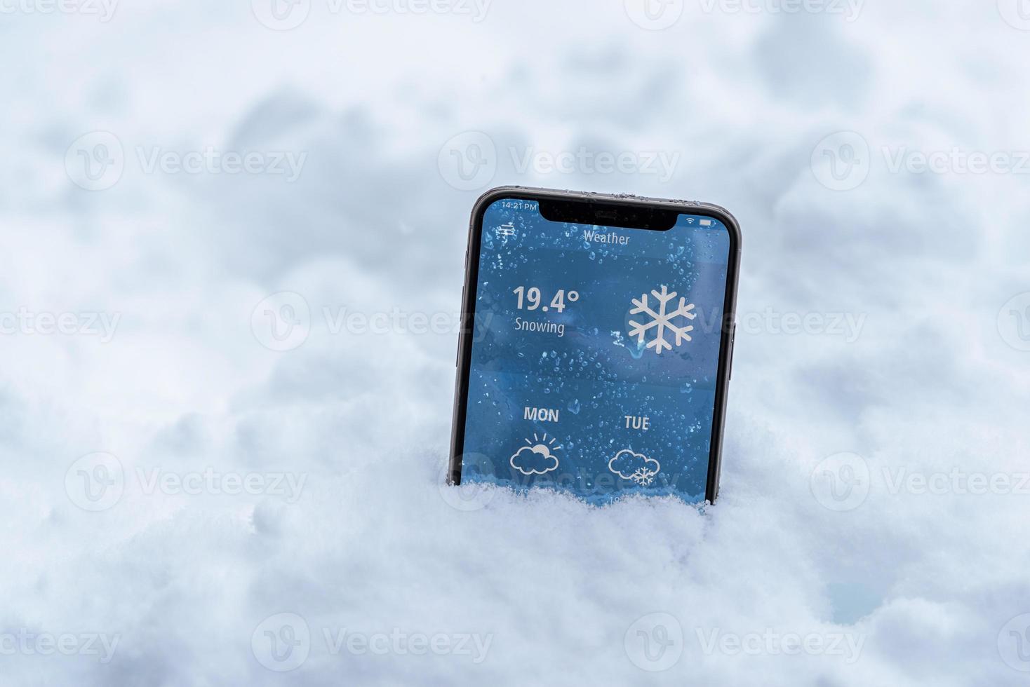 Phone in the snow with a weather forecast shows the temperature in fahrenheit photo