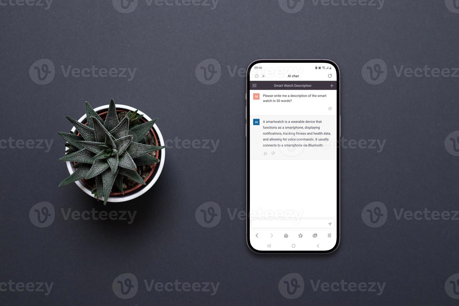Mobile phone on the desk with a chatbot AI app. Conceptual design of app to communicate with artificial inteligence. Plant beside, top view, flat lay photo