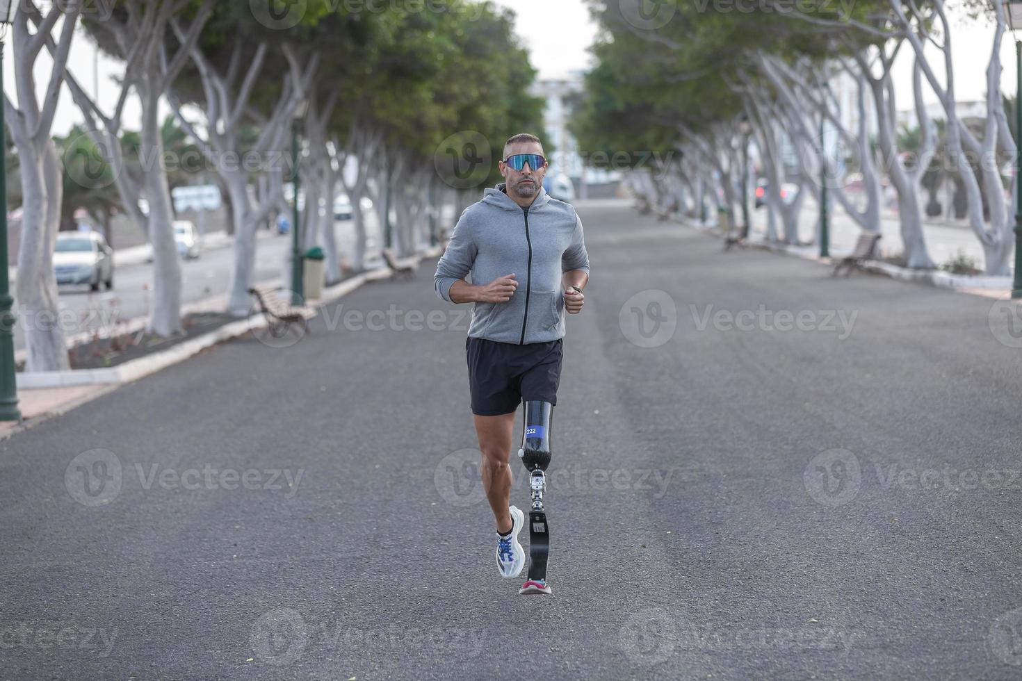 Handicapped sportsman running in park photo