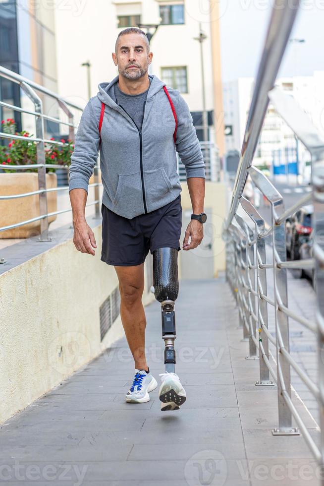 Handicapped male athlete walking on slope photo
