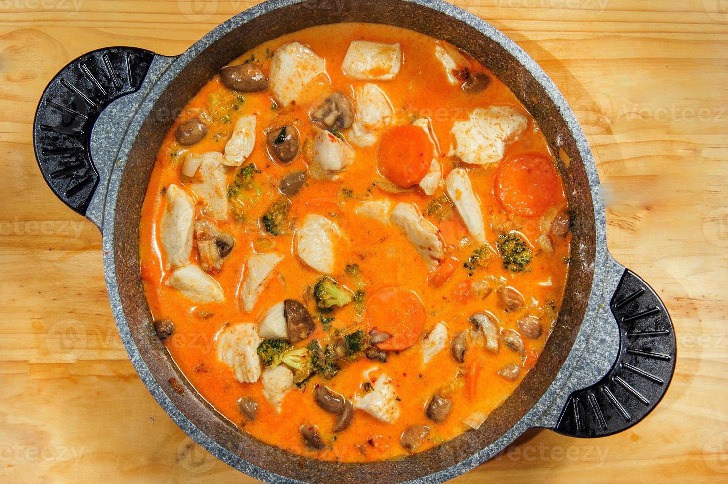 Spicy vegitable chicken cooked with red sauce in dowl. photo