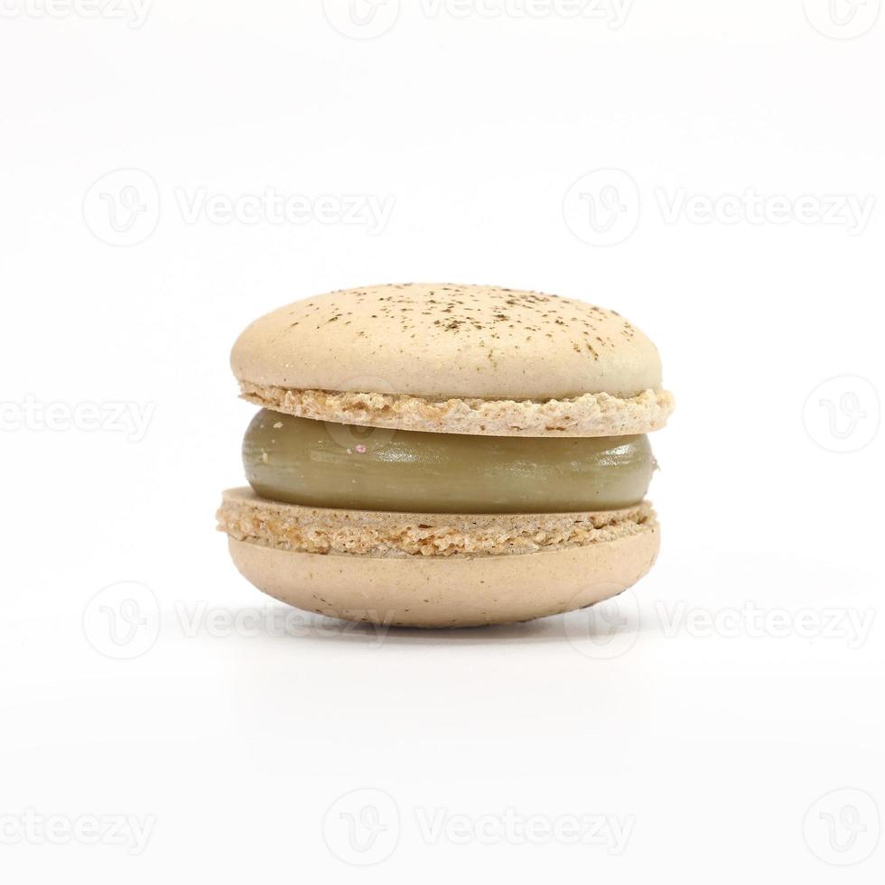 One cake of macaroni pistachio color. Delicious caramel macaroon isolated on black background. French sweet cookie photo