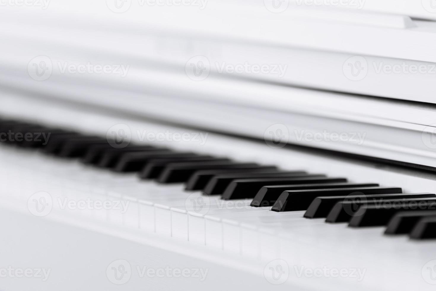 Close side view of shiny black and white piano keys with the reflection of the white edge from low angle with shallow depth of field. selective focus photo