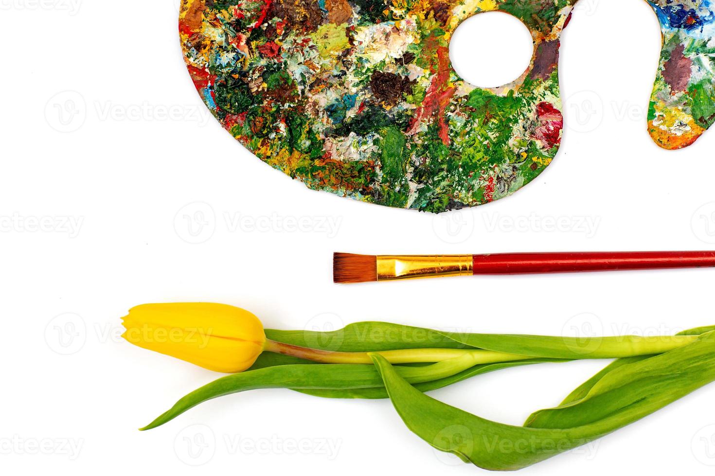 Palette with colorful paints. Colorful oil painting palette with a brush reaching in. Paint brushes and paints for drawing. tulip on a white background photo