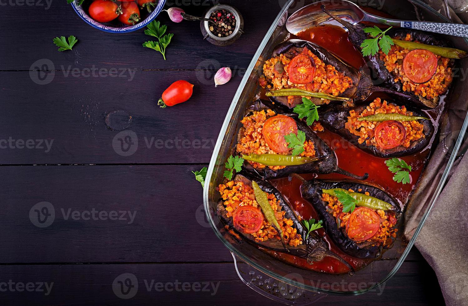 Karniyarik - turkish traditional aubergine eggplant meal. Stuffed eggplants with ground beef and vegetables baked with tomato sauce. Turkish cuisine. Top view. Copy space photo