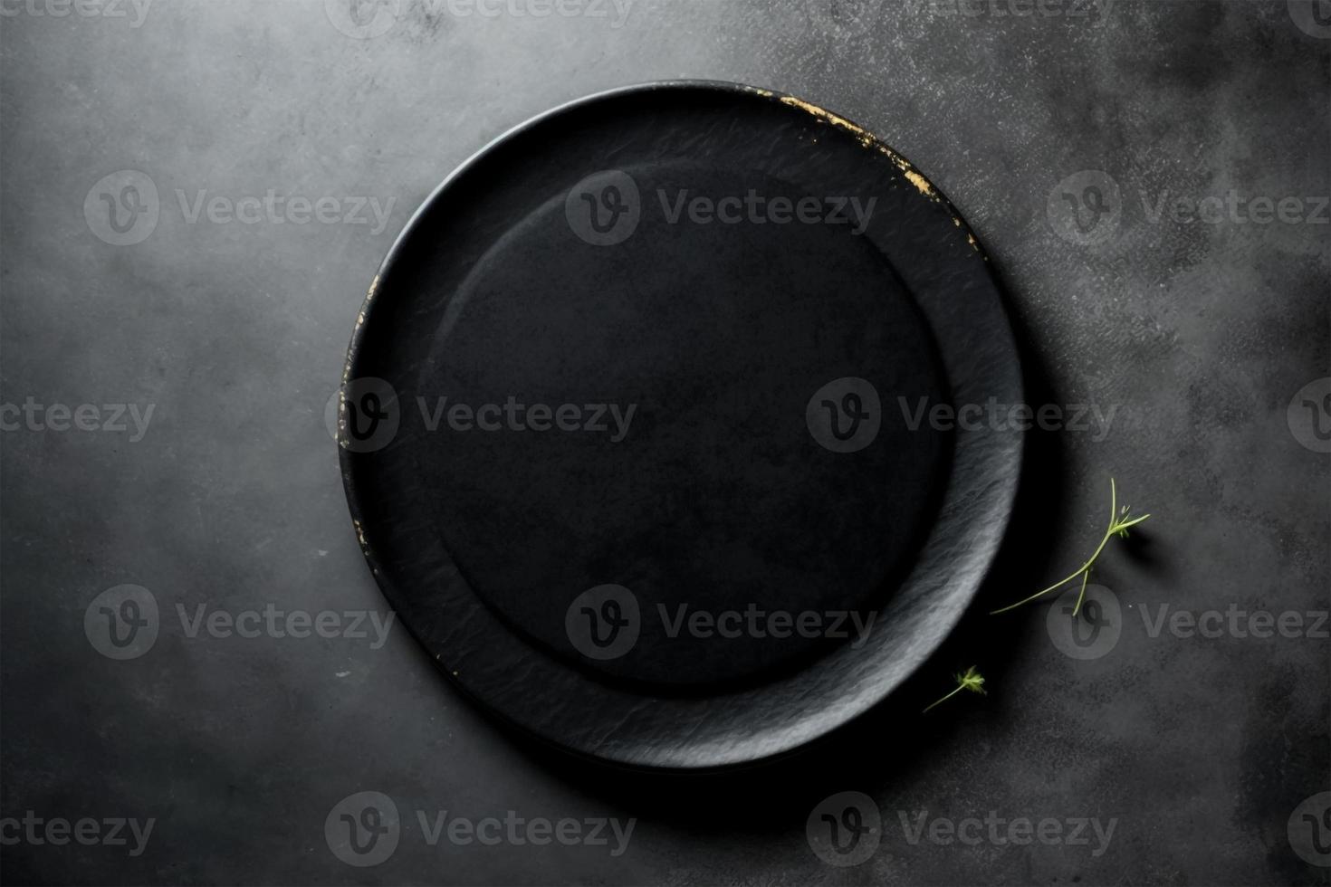 Black plate on stone table top view. Empty space for menu or recipe. photo