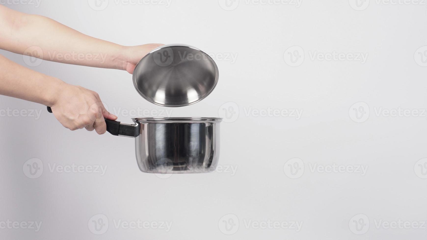 Pot cleaning Man hand on white background cleaning the non stick pot with handy dish washing sponge which yellow color on the soft side and green on hard side for hygiene after cook. Electric pot photo