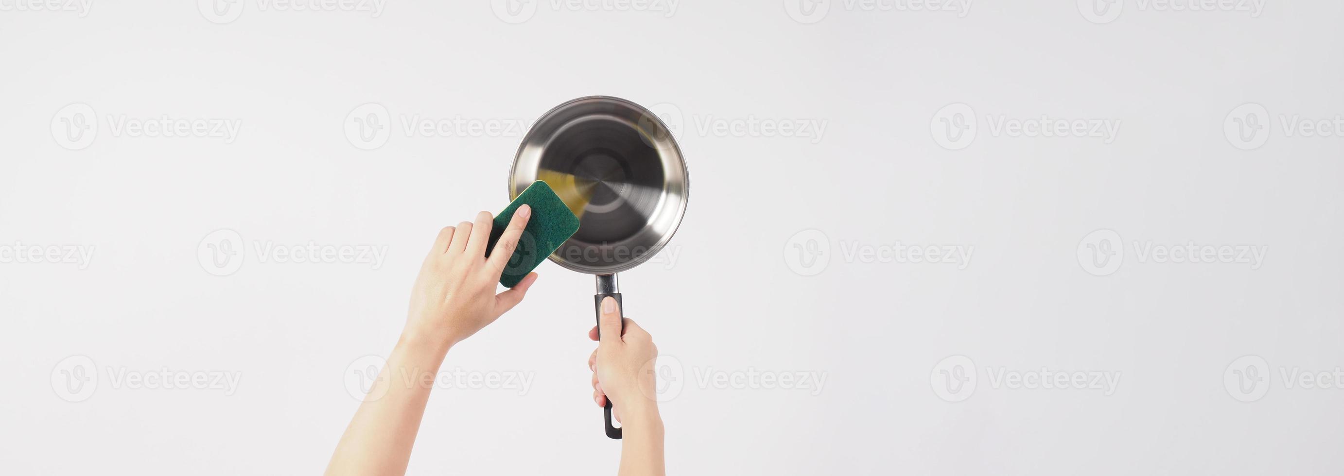 Pot cleaning Man hand on white background cleaning the non stick pot with handy dish washing sponge which yellow color on the soft side and green on hard side for hygiene after cook. Electric pot photo