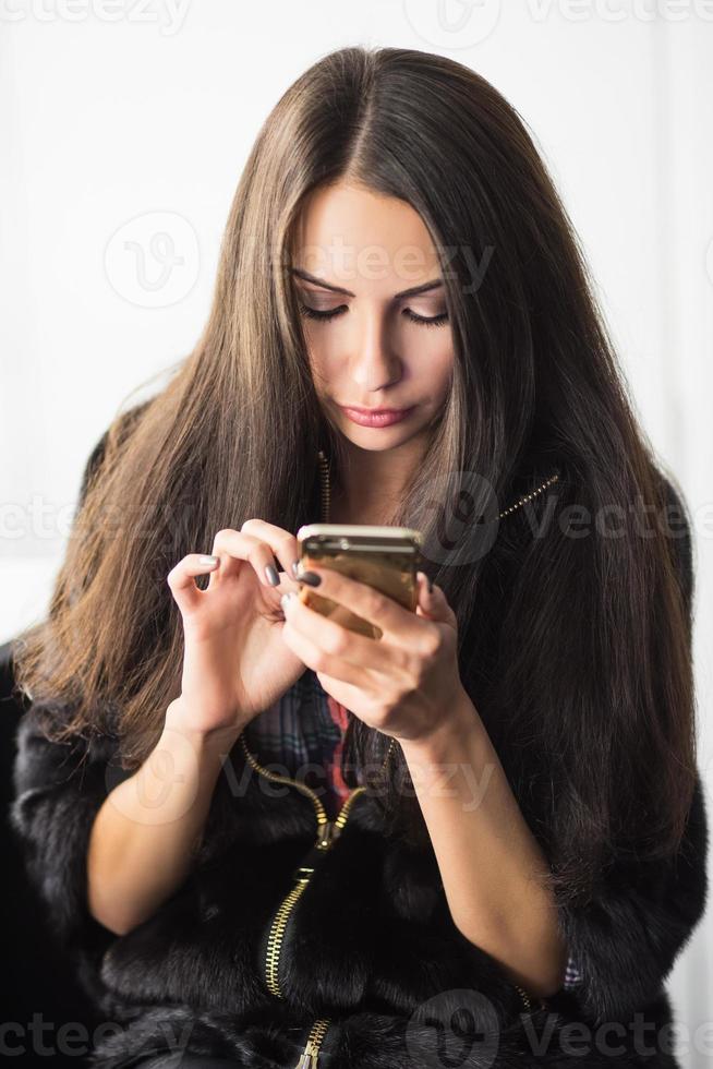 joven morena con un teléfono foto