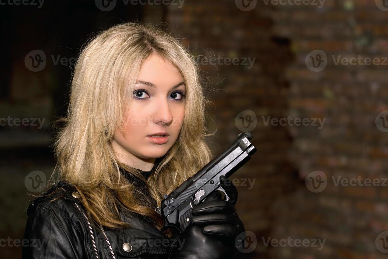 Scared beautiful woman with a gun photo