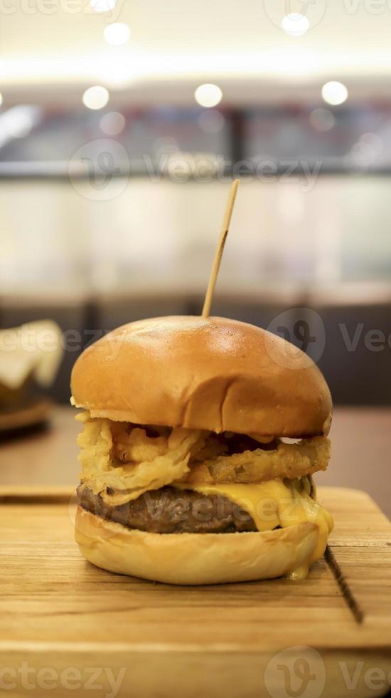 Beef brisket burger which contain bearnaise sauce, tomato, relish, onion rings and mozzarella cheese. photo