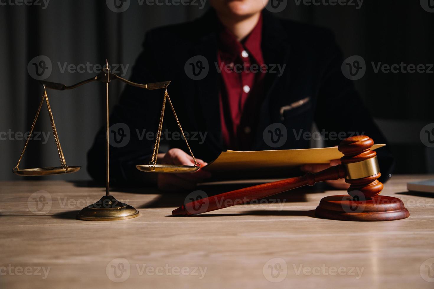 concepto de justicia y derecho. juez masculino en una sala de audiencias con el mazo, trabajando con computadora y teclado de acoplamiento, anteojos, en la mesa a la luz de la mañana foto