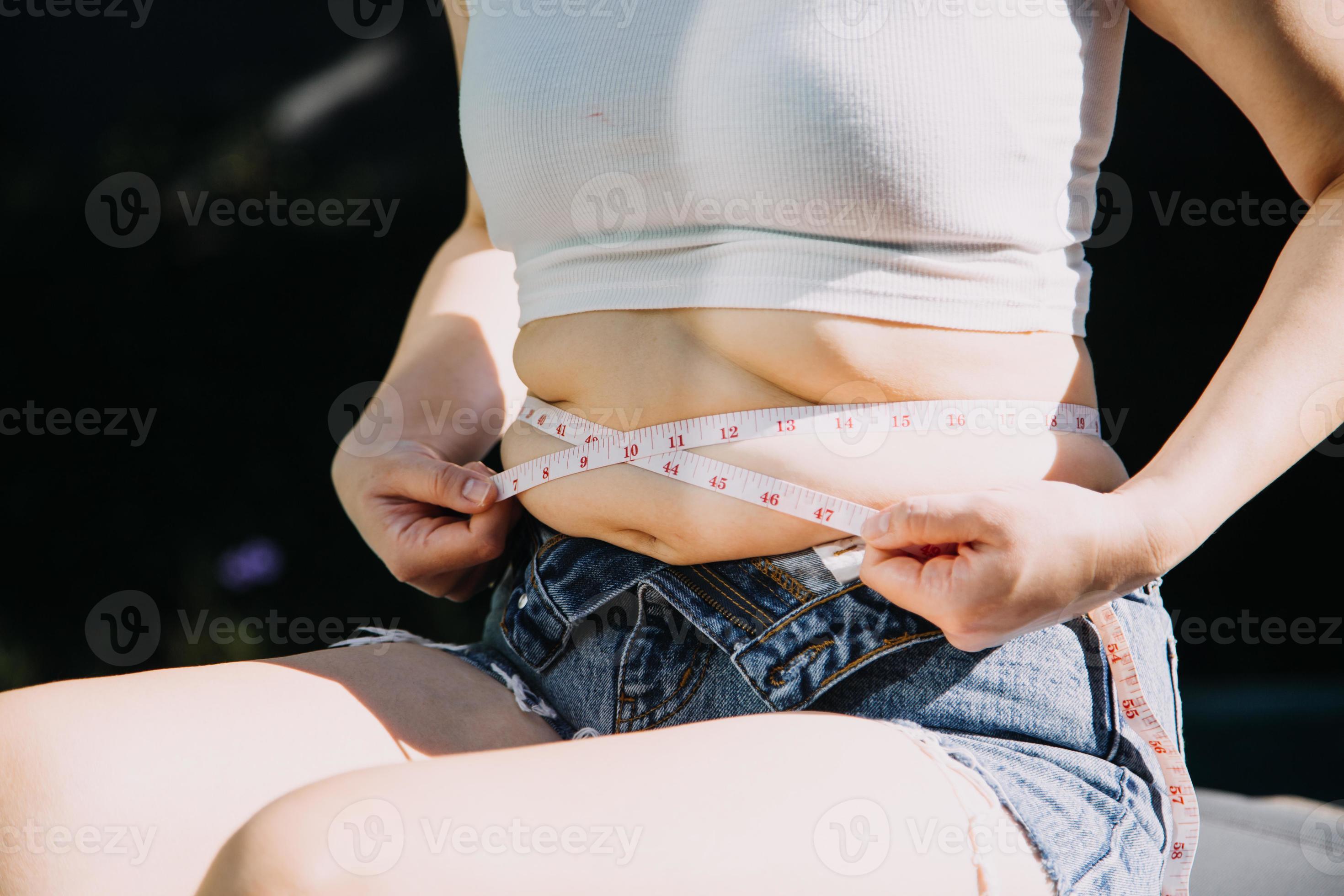 Woman measuring waist with measuring tape,Excess belly fat and