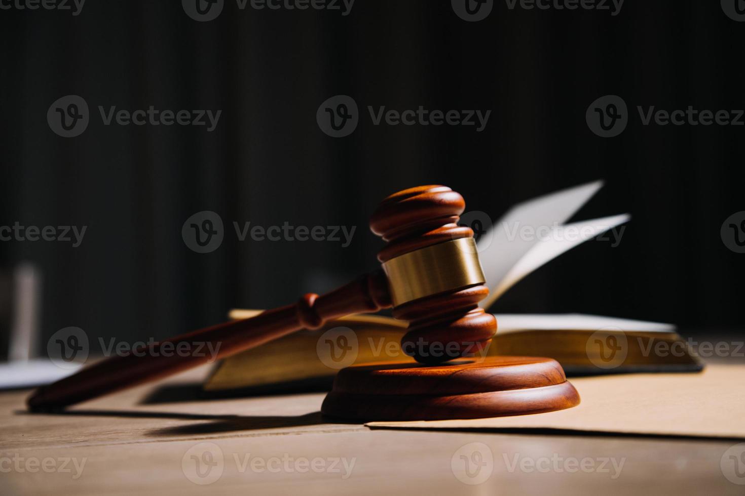 Justice and law concept.Male judge in a courtroom with the gavel, working with, computer and docking keyboard, eyeglasses, on table in morning light photo