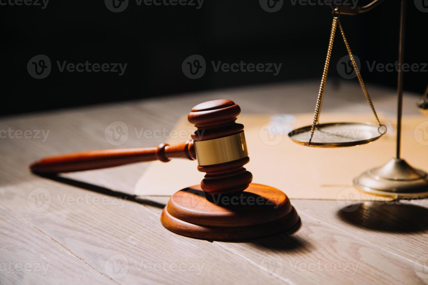 Justice and law concept.Male judge in a courtroom with the gavel, working with, computer and docking keyboard, eyeglasses, on table in morning light photo