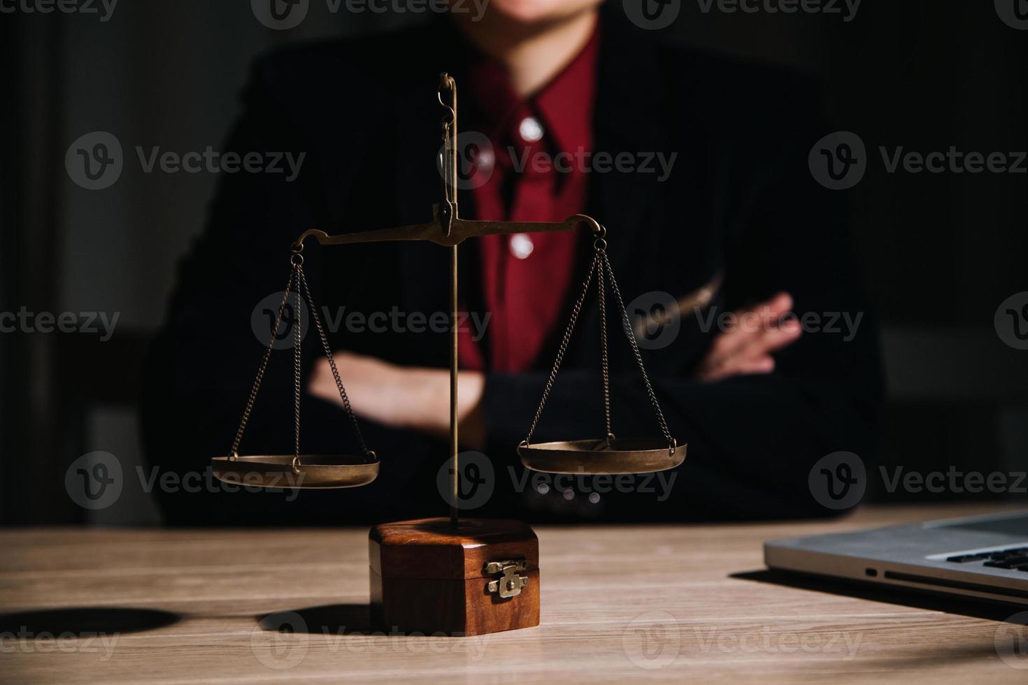 concepto de justicia y derecho. juez masculino en una sala de audiencias con el mazo, trabajando con computadora y teclado de acoplamiento, anteojos, en la mesa a la luz de la mañana foto