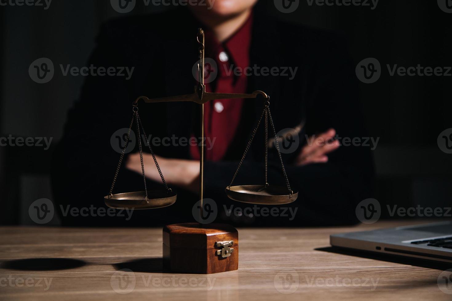 concepto de justicia y derecho. juez masculino en una sala de audiencias con el mazo, trabajando con computadora y teclado de acoplamiento, anteojos, en la mesa a la luz de la mañana foto