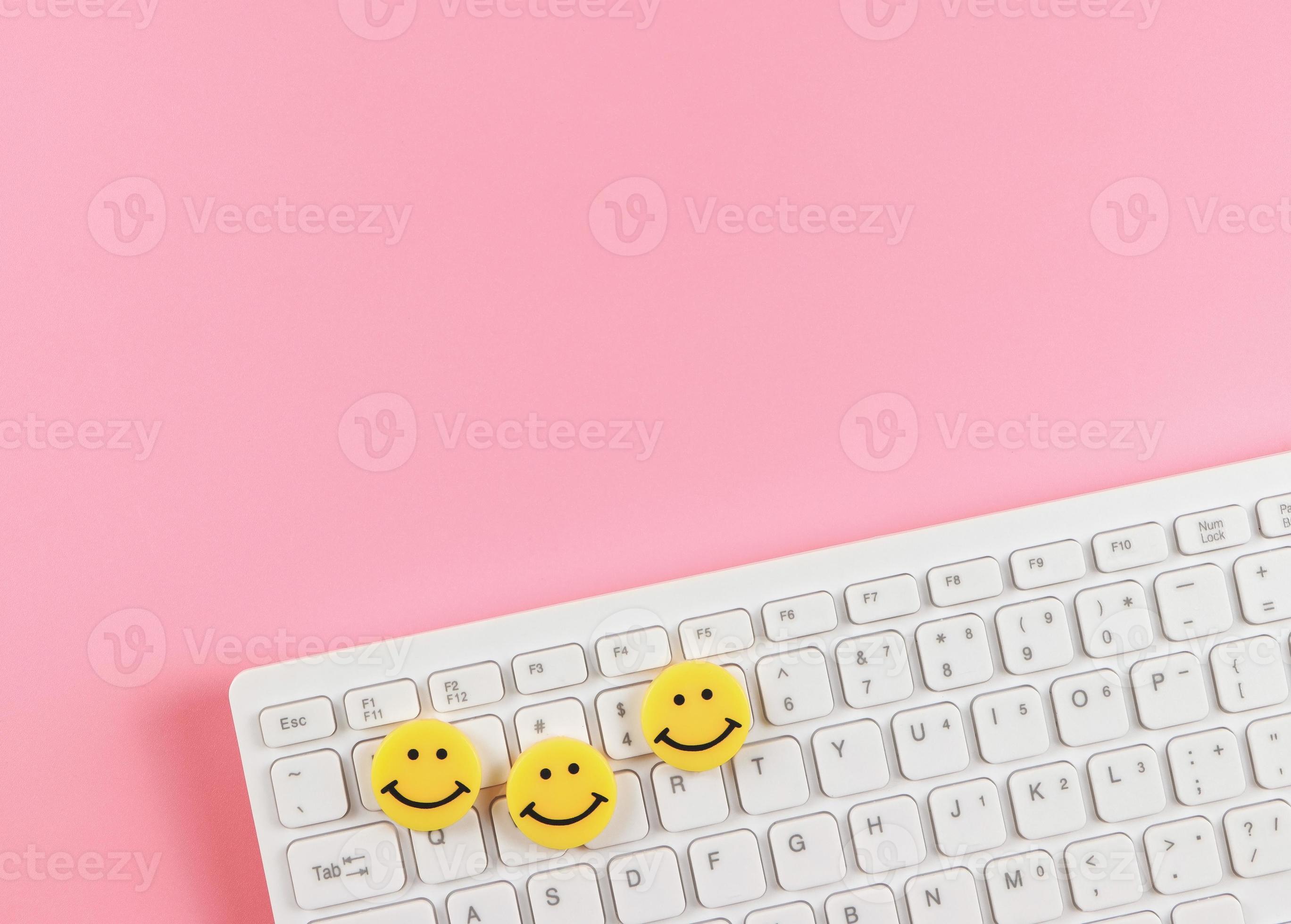 flat lay of threes yellow circle smiling faces on white computer