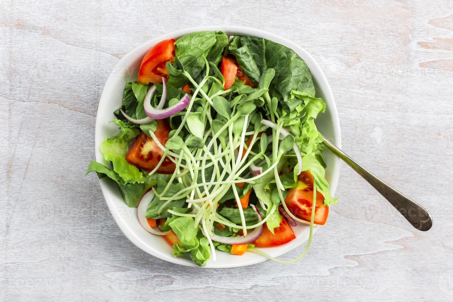 SunflowerHealthy food sunflower sprout salad has leave lettuce vegetable tomato in bowl on white wood background. photo