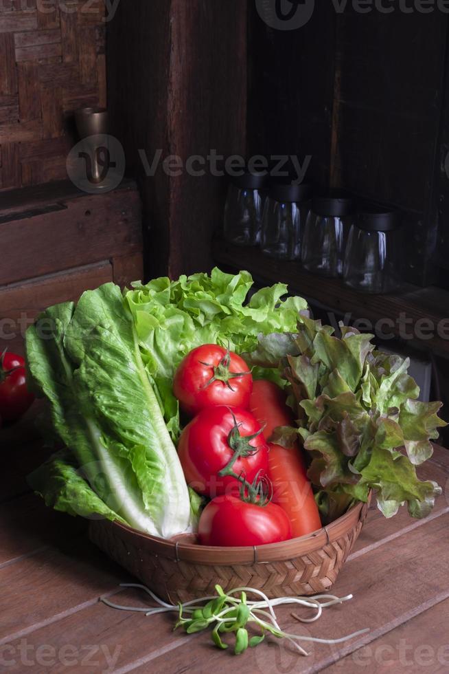 comida saludable vegetal lechuga roja y zanahoria de tomate romana en una cesta sobre una mesa de madera, vista superior, espacio para copiar. foto