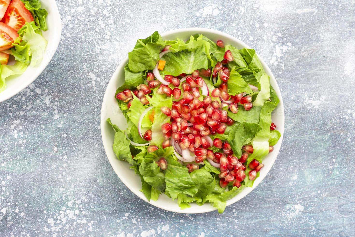 Healthy food pomegranate vegetable salad in bowl on blue wood background. photo