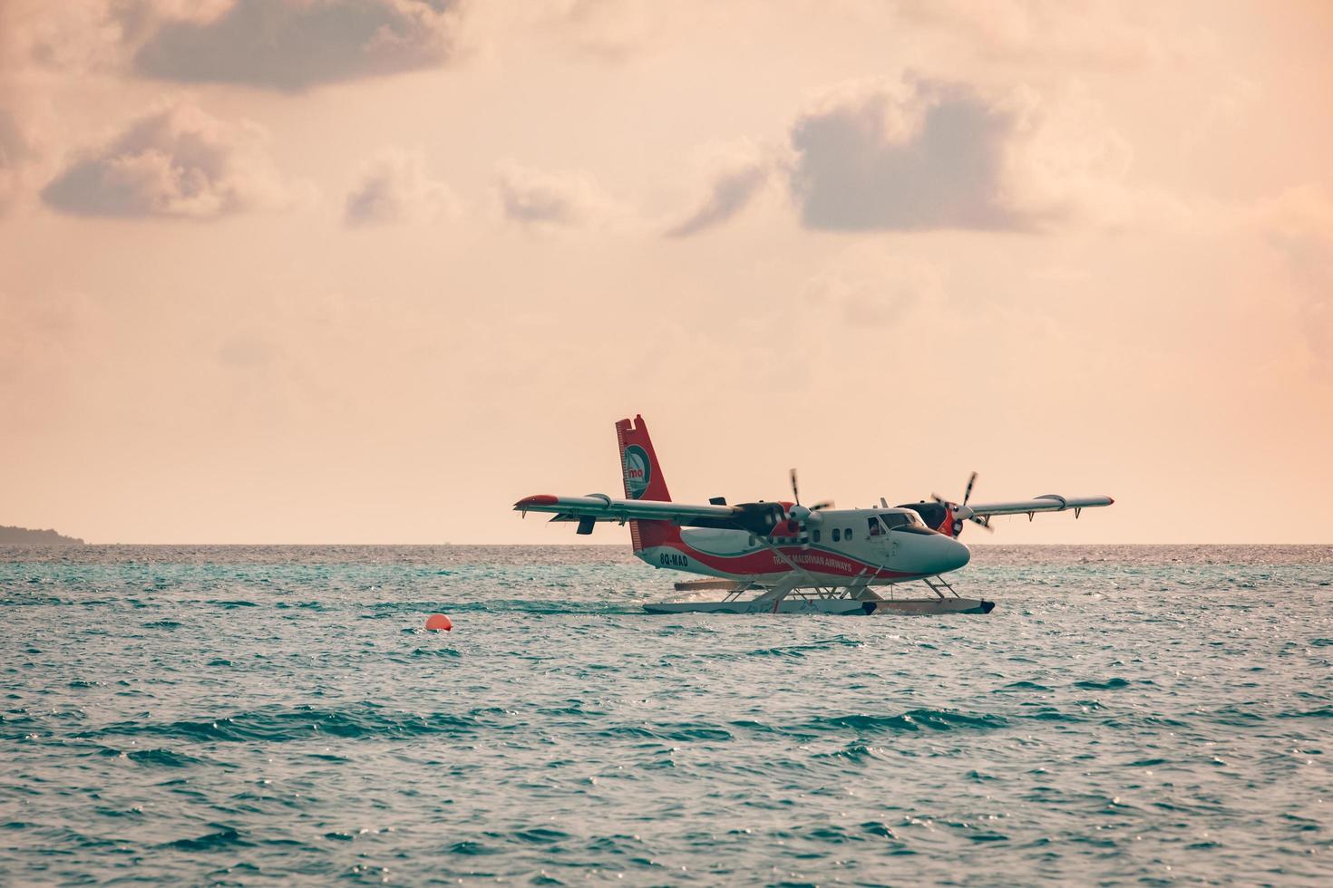 08.09.2019 - Ari Atoll, Maldives Exotic scene with seaplane on Maldives sea landing. Seaplane taxi on sunset sea before takeoff. Vacation or holiday in Maldives concept background. Air transportation photo