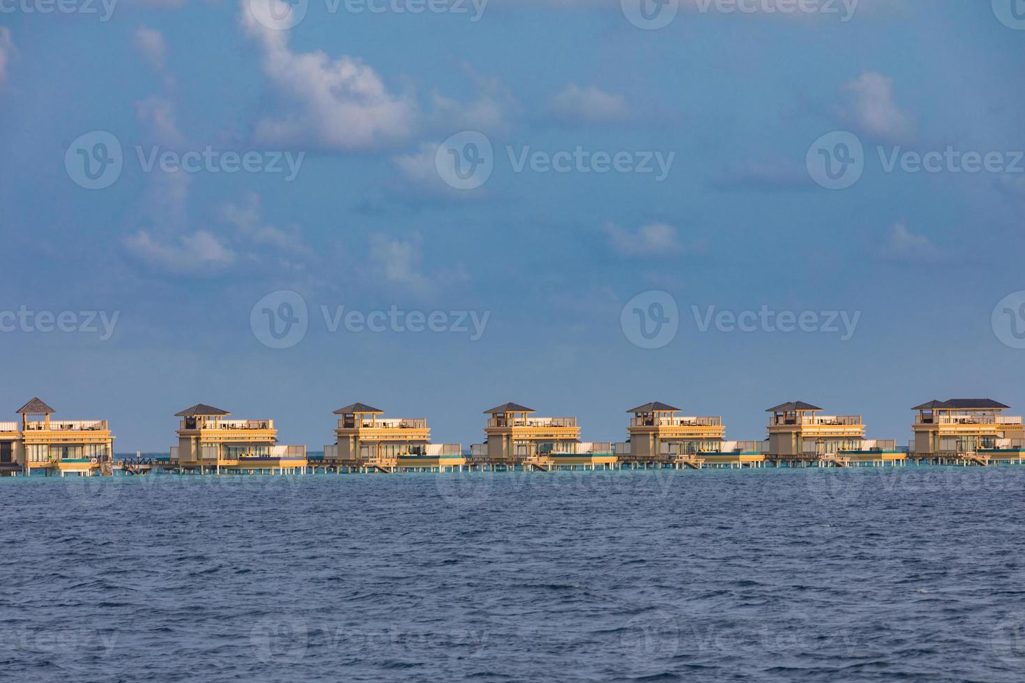complejo de villas de agua. isla de maldivas, océano índico. vista desde el barco, bungalows exóticos de lujo sobre el agua. concepto de viajes y turismo de verano, elementos de arquitectura en el agua foto