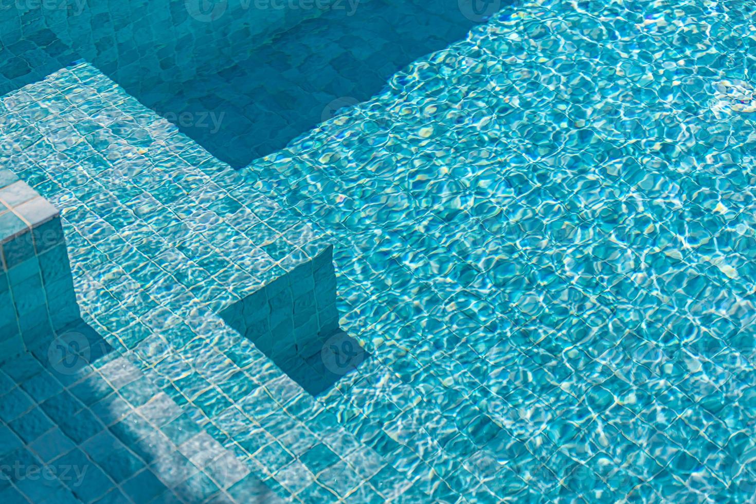Beautiful pool water with relaxing sun sparkles on surface. Summer vacation or holiday concept, swimming pool texture photo