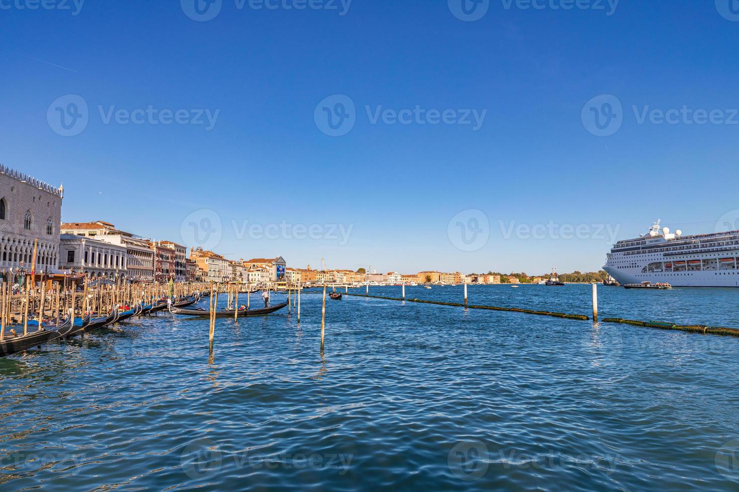 Big cruise ship with tourists leaving the city of Venice Italy on sunny day. Issue for the preservation of Venice fragile environment and city historic heritage photo