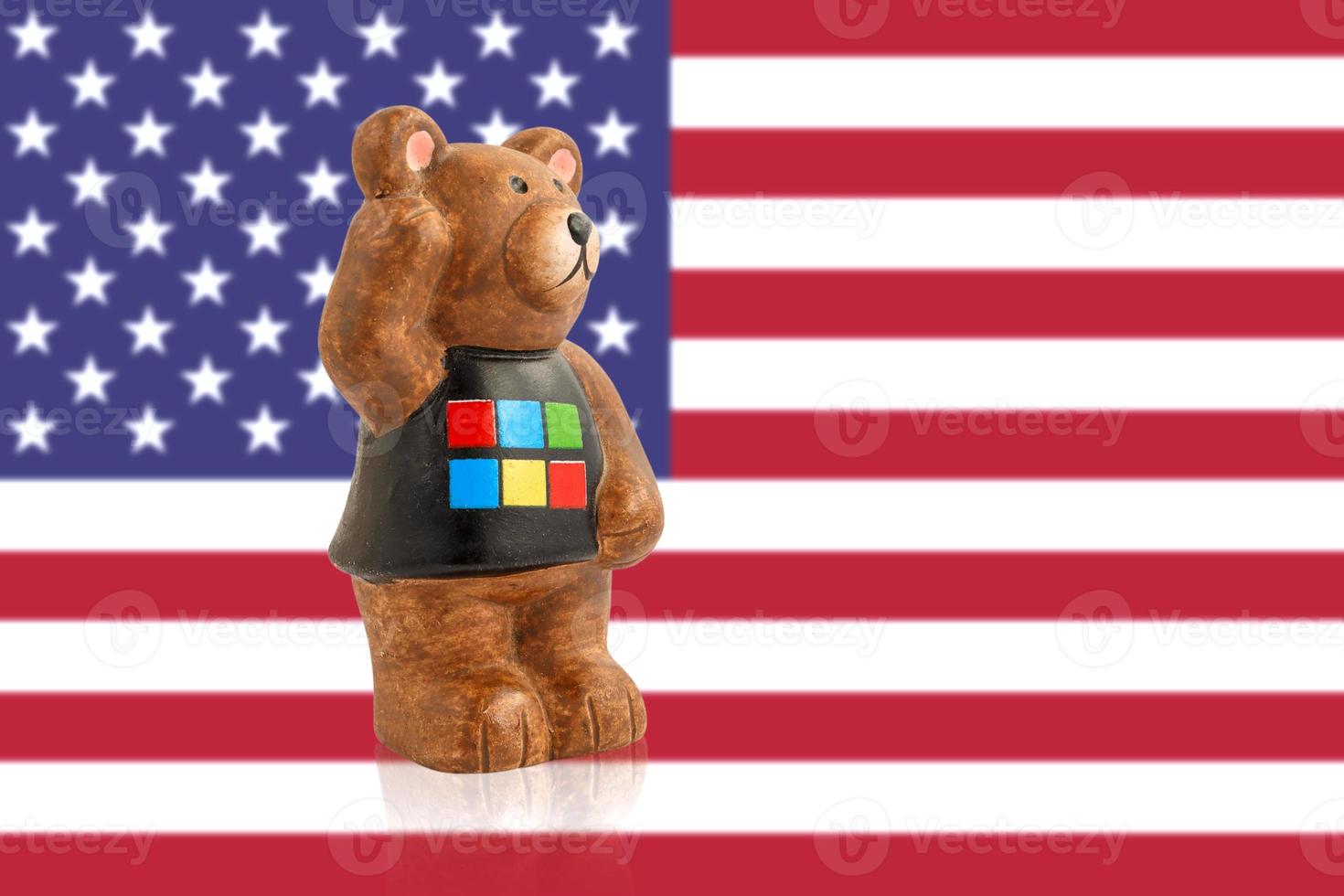 Bear figurine against the background of the USA flag. Blurred background. photo