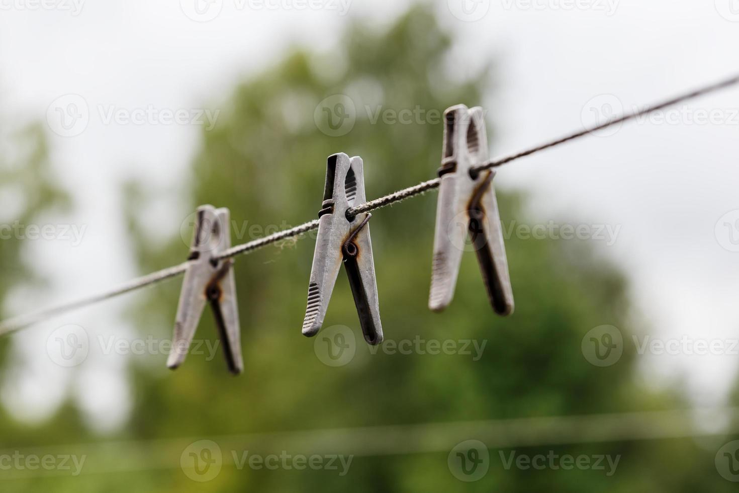 pinzas para la ropa colgando de una cuerda. pinzas para la ropa cuelgan de un tendedero. fondo borroso foto