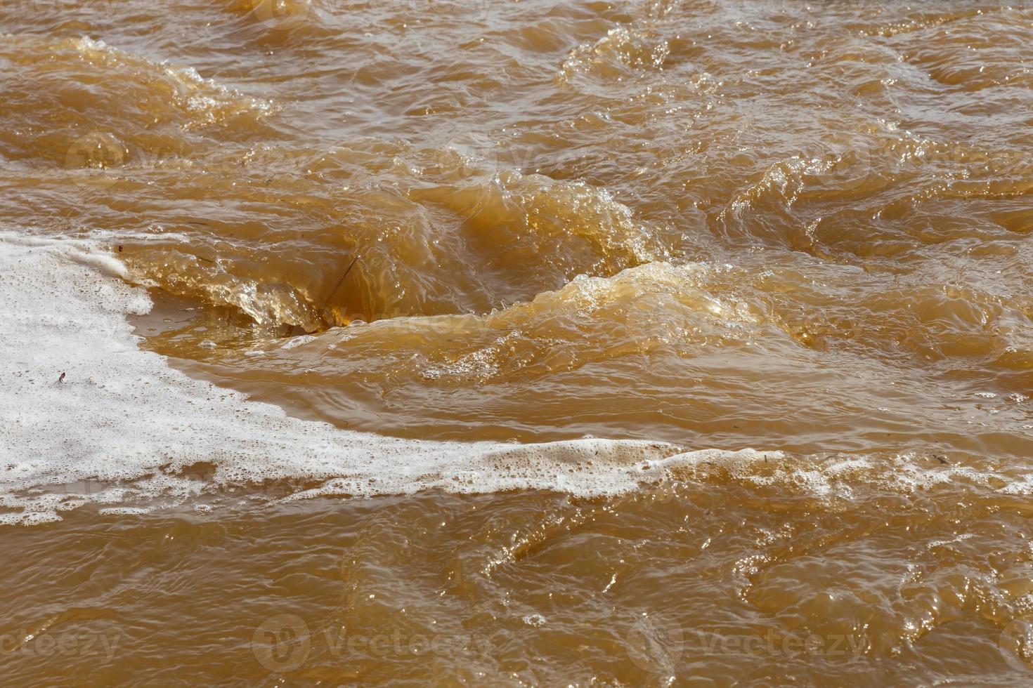 agua fangosa del río. agua fangosa sucia con hidromasaje y primer plano de espuma blanca. foto