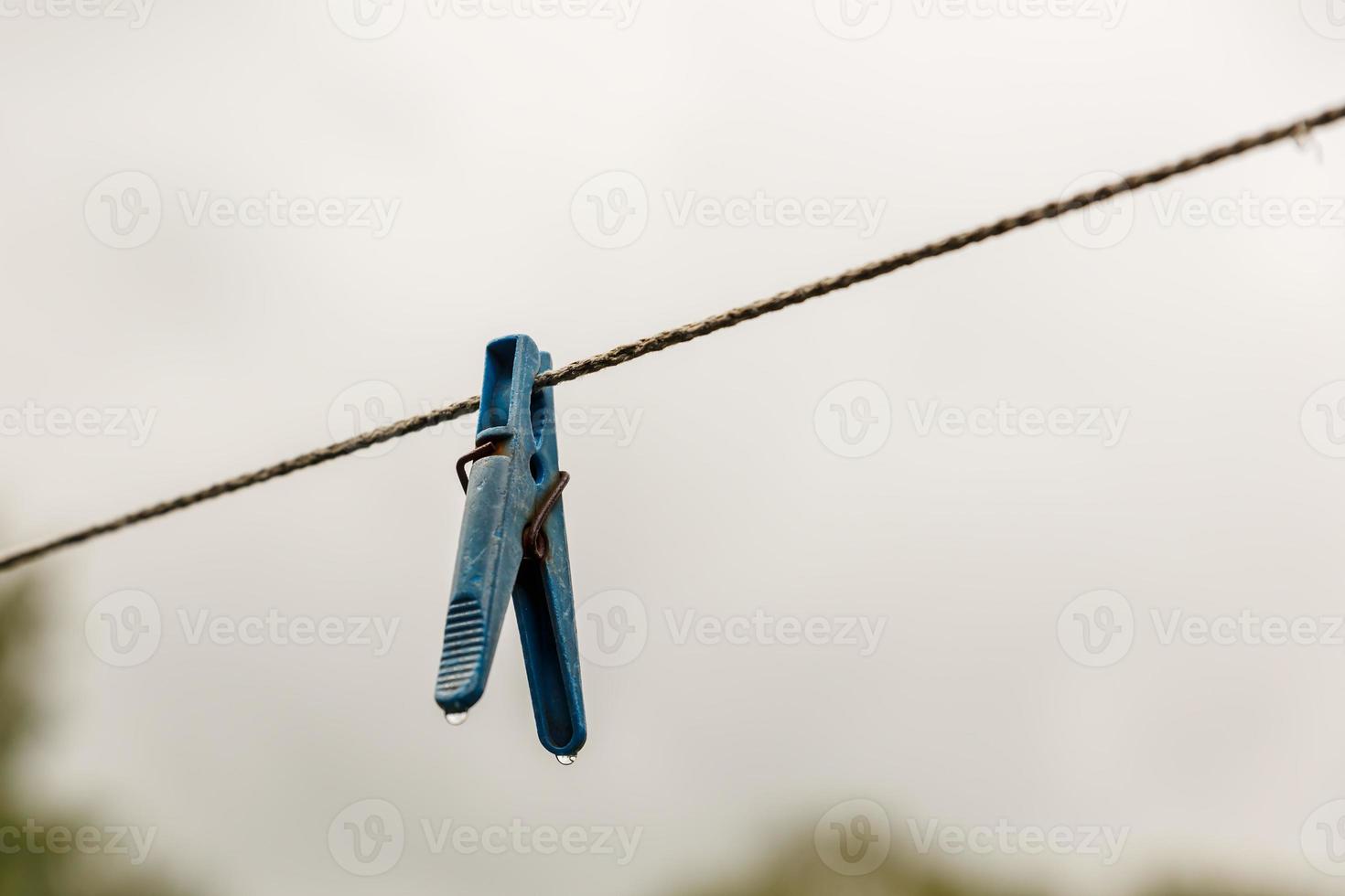 clothespin hanging from a rope. A clothespin hangs from the clothesline. Blurred background. photo