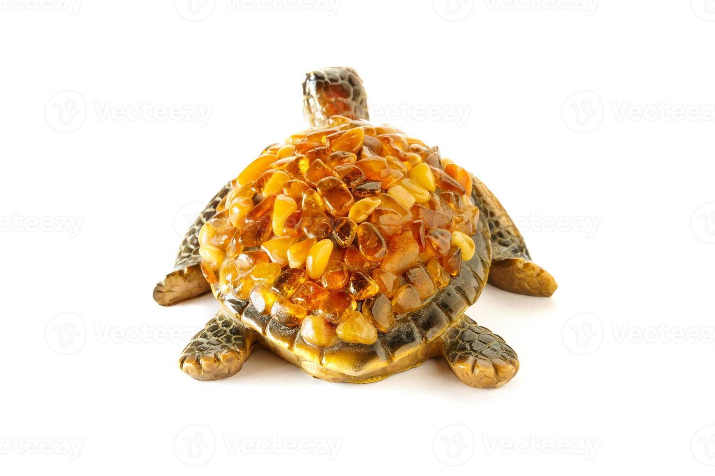 Figurine of a turtle on a white background with amber stones on the shell. Back view. photo