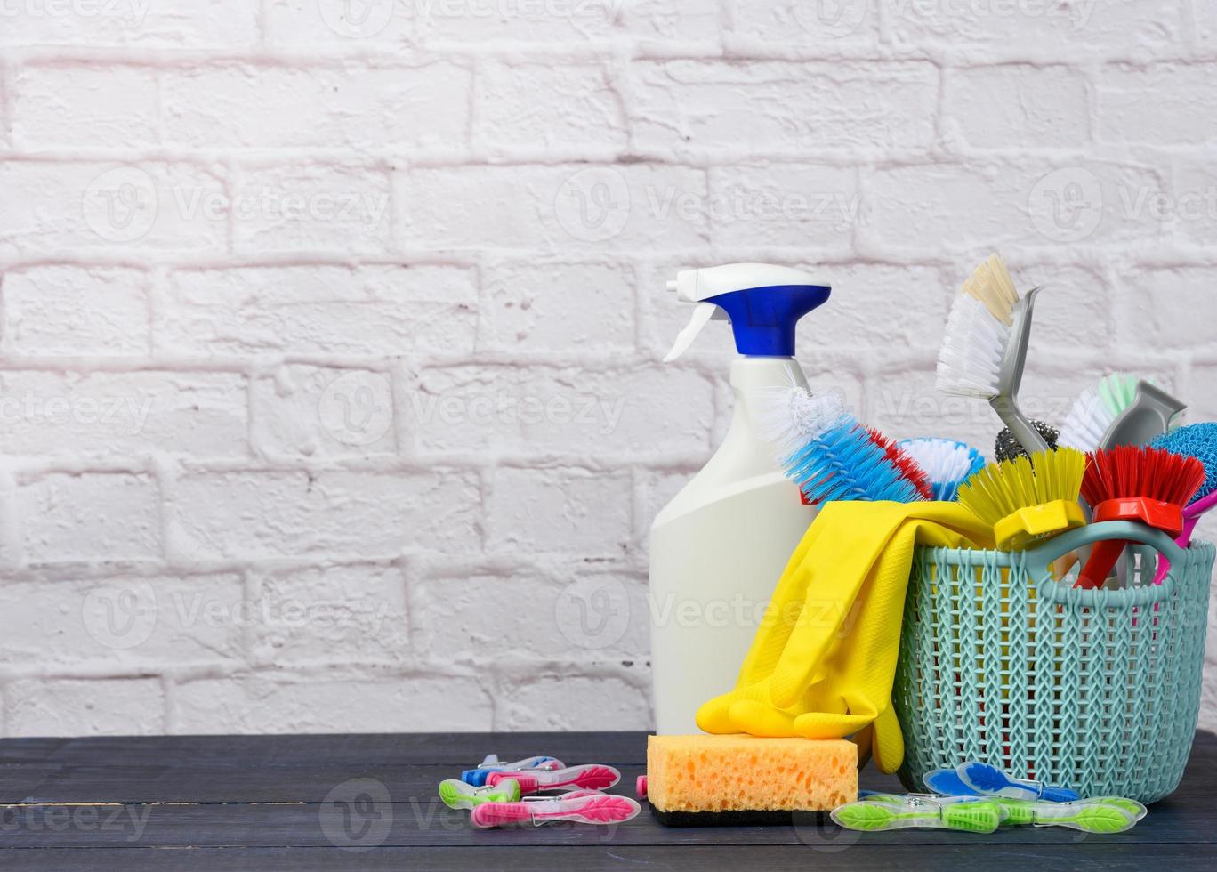 blue plastic basket with brushes, sponges and rubber gloves for cleaning photo