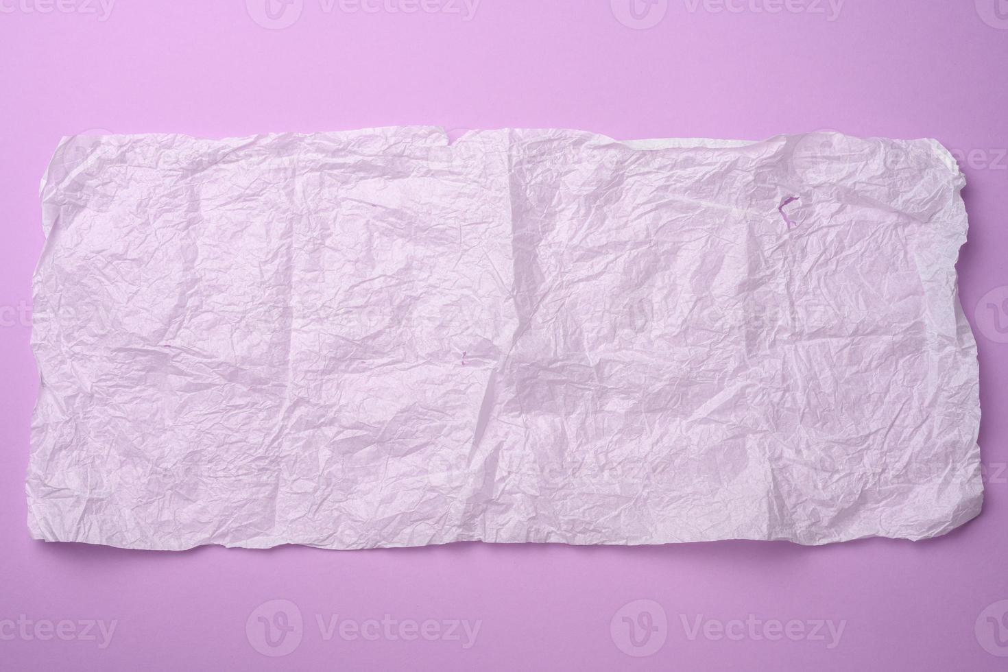 rectangular crumpled sheet of paper in tissue on a purple background photo