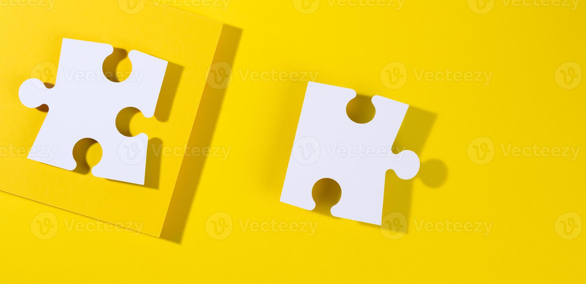 large blank white paper puzzle with shadow on yellow background, top view photo