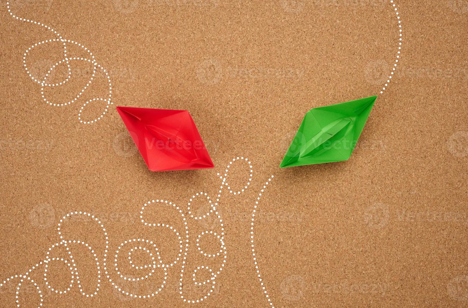 two paper boats with different trajectory on a brown background. The concept of optimal problem solving, achieving goals in different ways, smart and capable employee photo