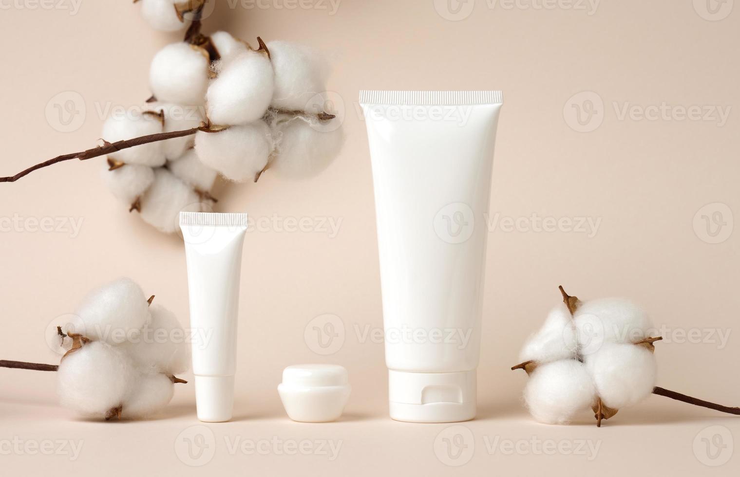 jar and empty white plastic tubes for cosmetics on a green background. Packaging for cream, gel, serum, advertising and product promotion, mock up photo