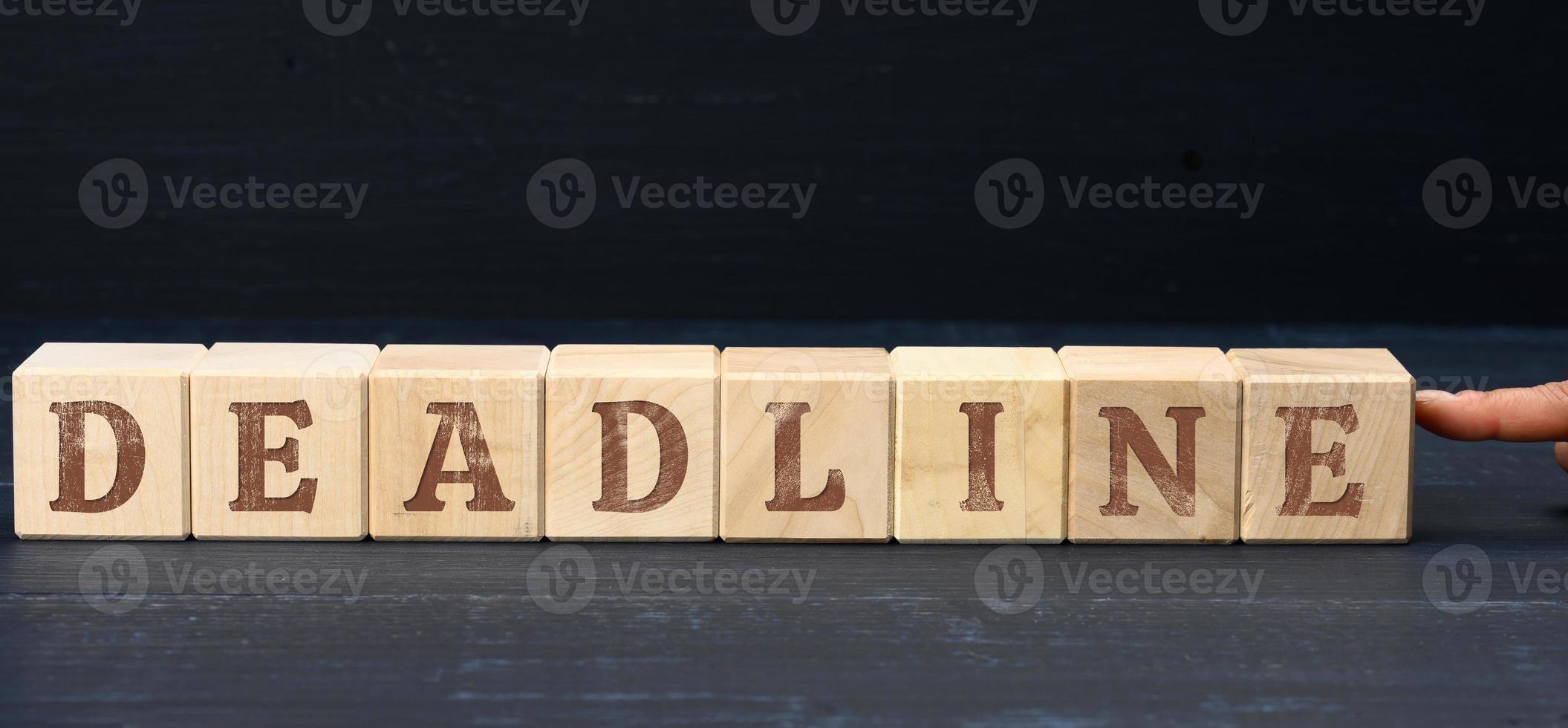wooden cubes with deadline inscription. The last due date, date, or time by which the task should be completed photo
