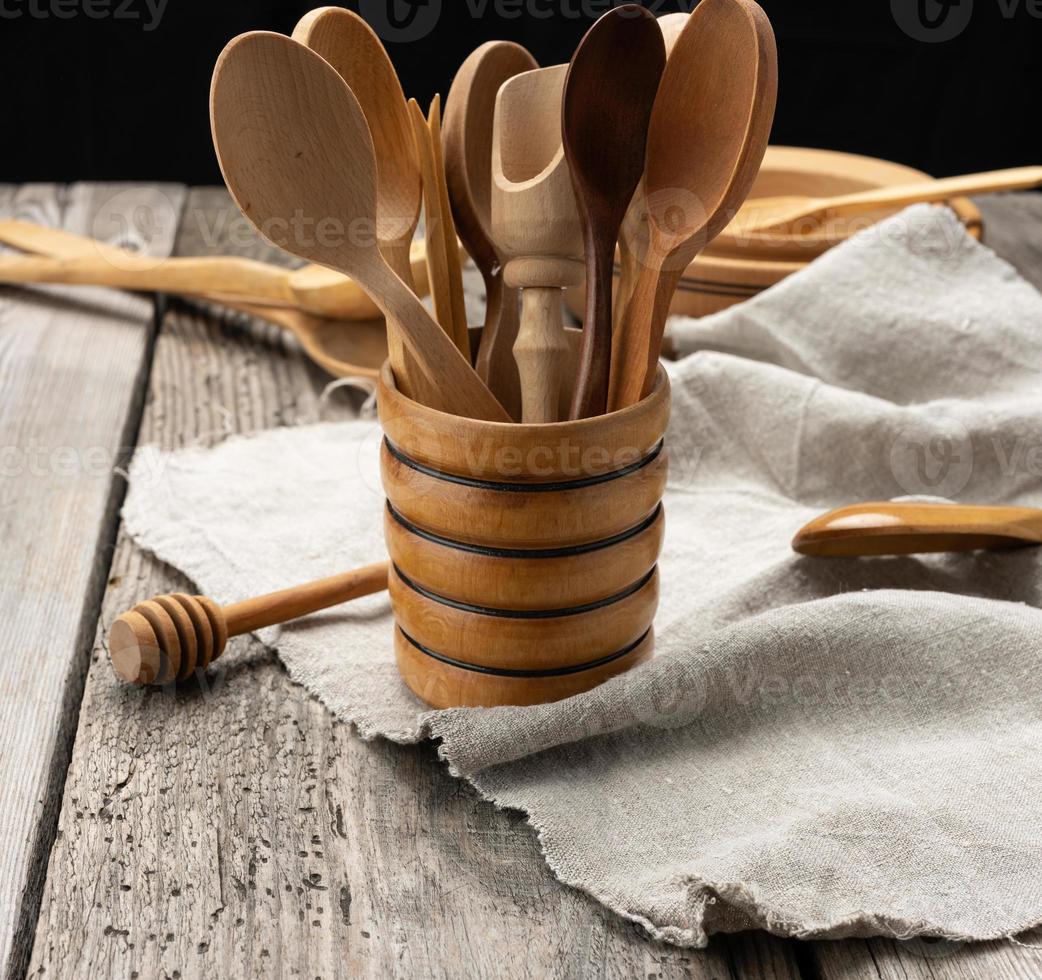 empty round wooden plates and spoons on a gray table photo