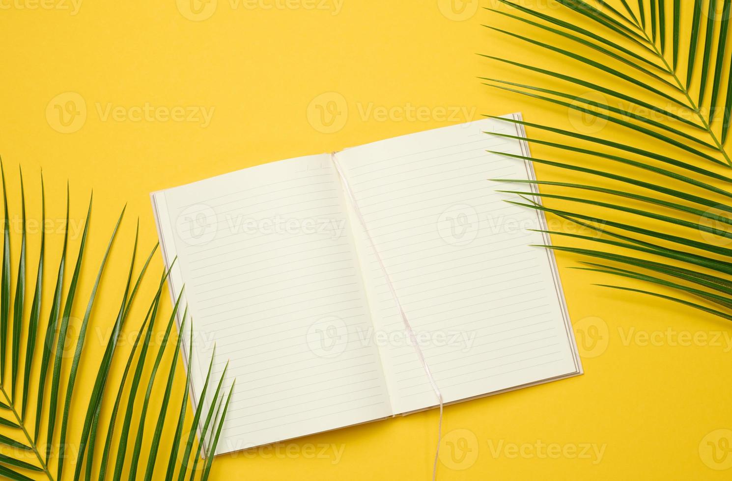 open notebook with blank white sheets on a yellow background, top view. photo