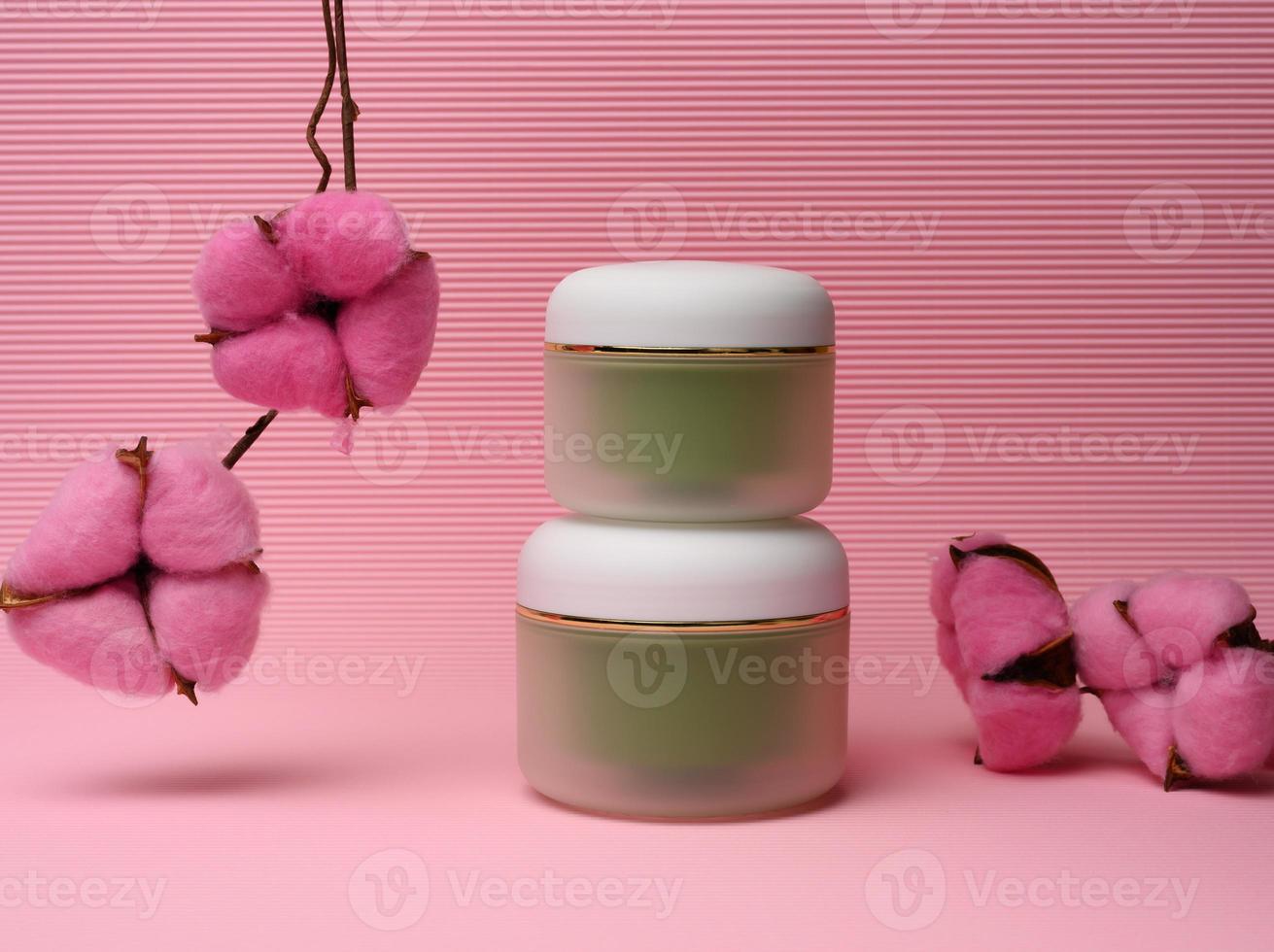 tarro verde para cosméticos sobre un fondo rosa. envases para crema, gel, suero, publicidad y promoción de productos foto