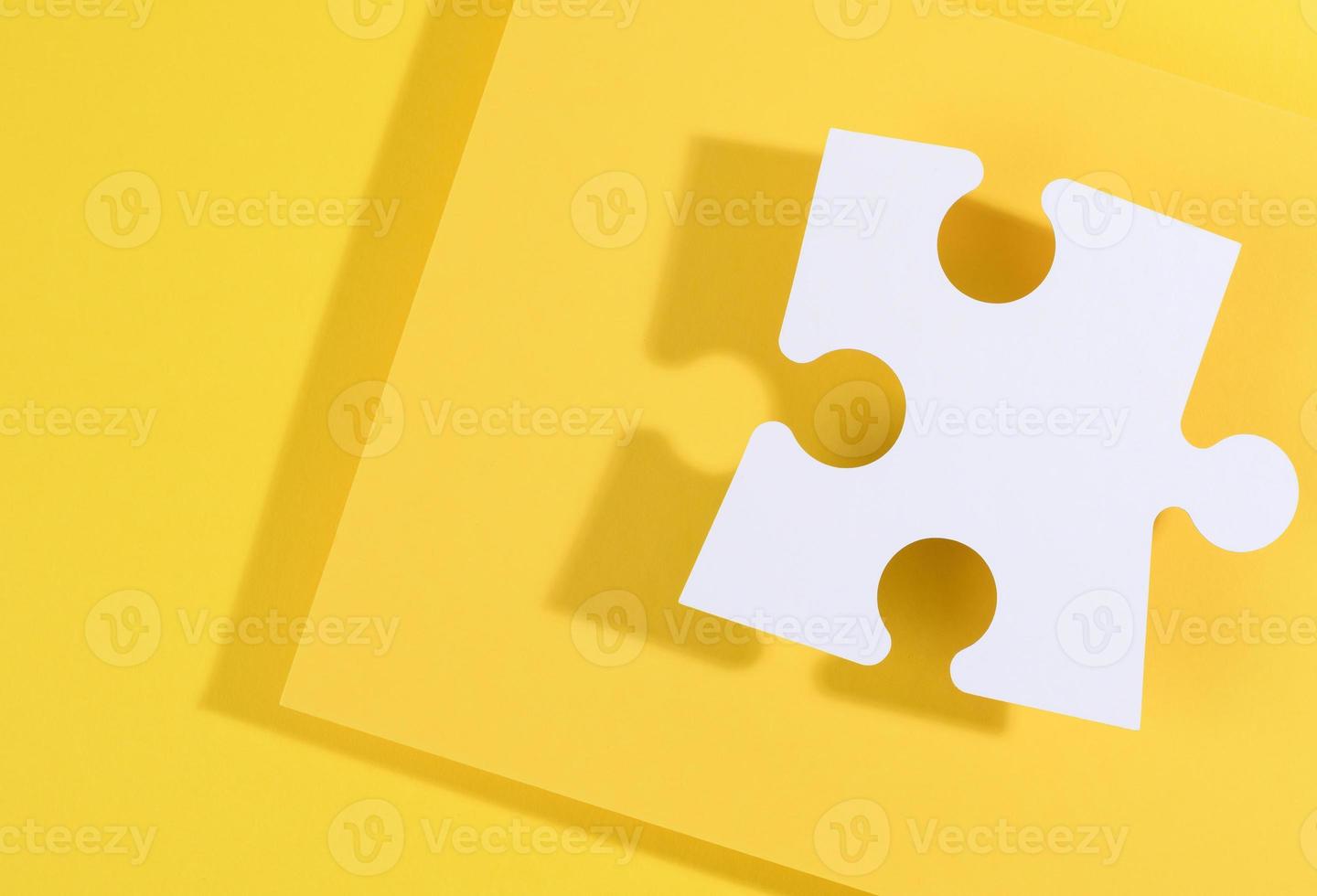 large blank white paper puzzle with shadow on yellow background, top view photo