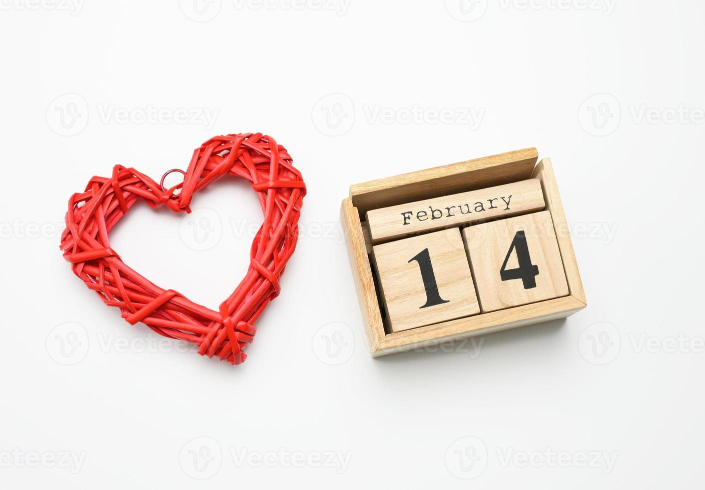 wooden calendar with date 14 February and red heart on white background photo