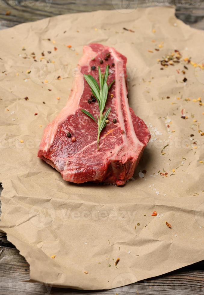 fresh raw piece of beef meat, striploin steak on a paper background, top view. Marbled piece of meat photo