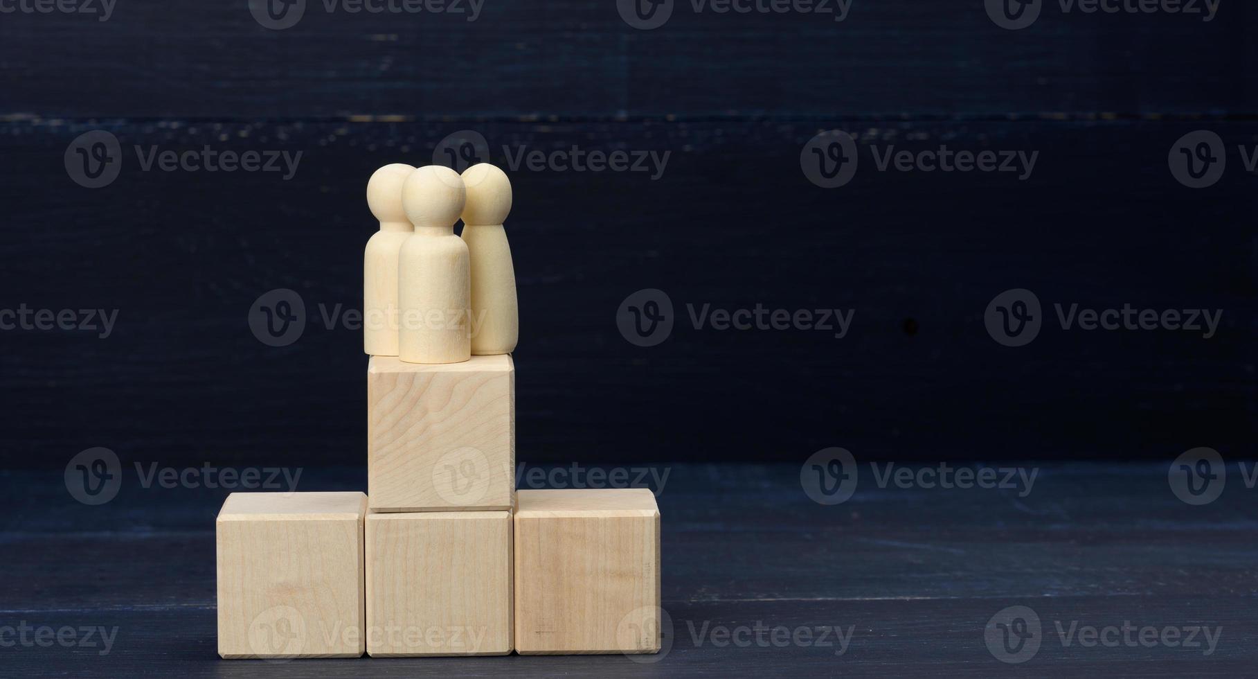 wooden figurines on top of the pyramid. The concept of well-coordinated teamwork, achieving goals photo