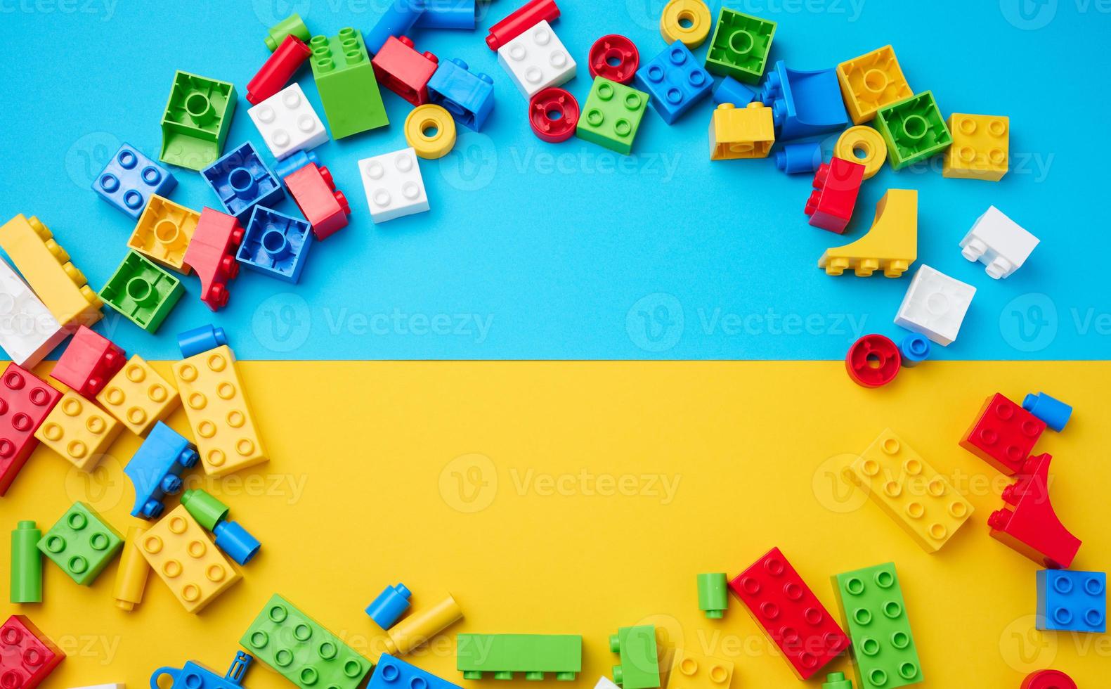 Scattered parts of a plastic children's designer, top view. Yellow blue background photo