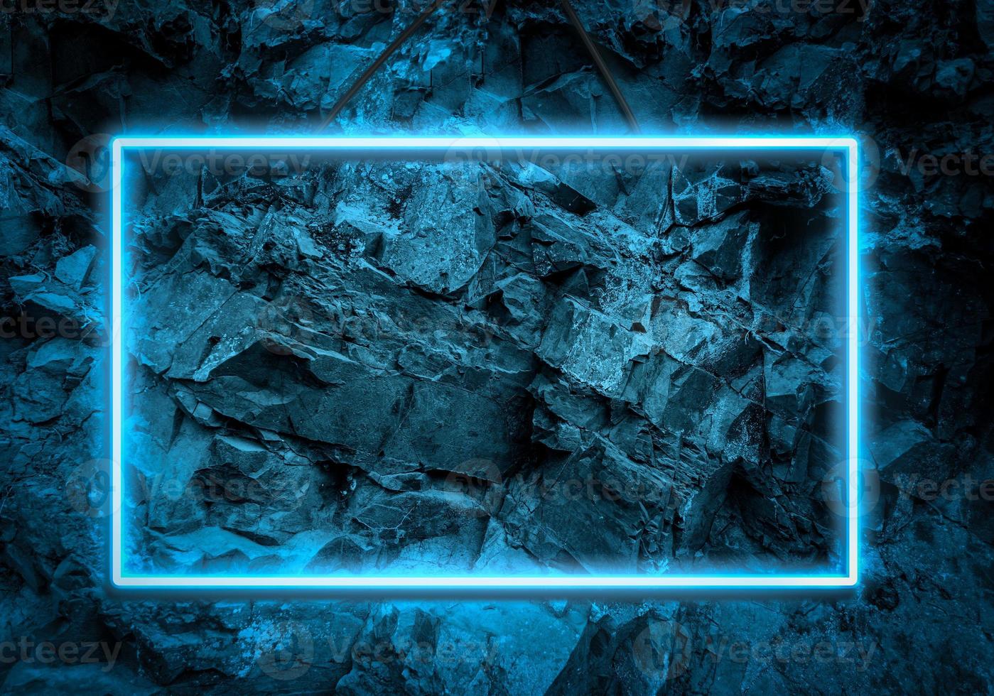 blue neon glowing frame on a background of a layer of stones photo