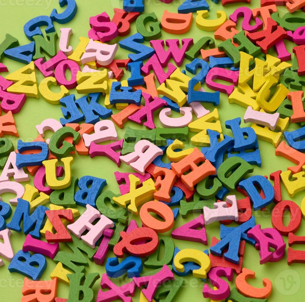 multicolored wooden letters of the english alphabet on a green background photo